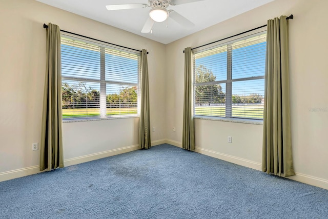 spare room with carpet flooring, a wealth of natural light, and ceiling fan