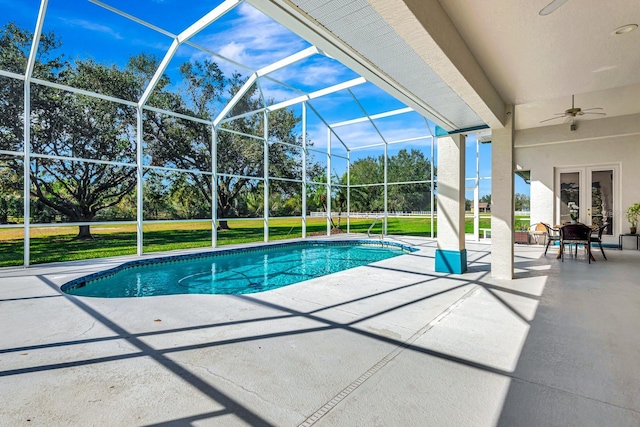 view of swimming pool featuring a lanai, a yard, ceiling fan, and a patio area