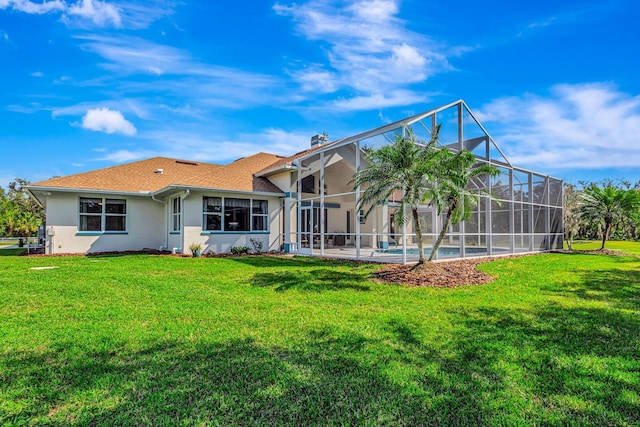 rear view of property featuring a yard, a lanai, and a patio