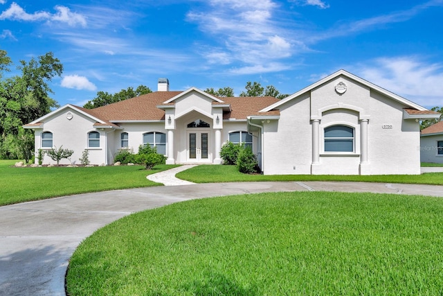 5750 Saddle Oak Trl, Sarasota, FL 34241 - view of front of house featuring french doors, a front lawn, a chimney, and stucco siding
