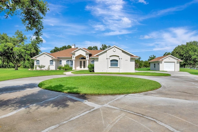 5750 Saddle Oak Trl, Sarasota, FL 34241 - mediterranean / spanish-style home featuring curved driveway, a front yard, a garage, an outbuilding, and french doors