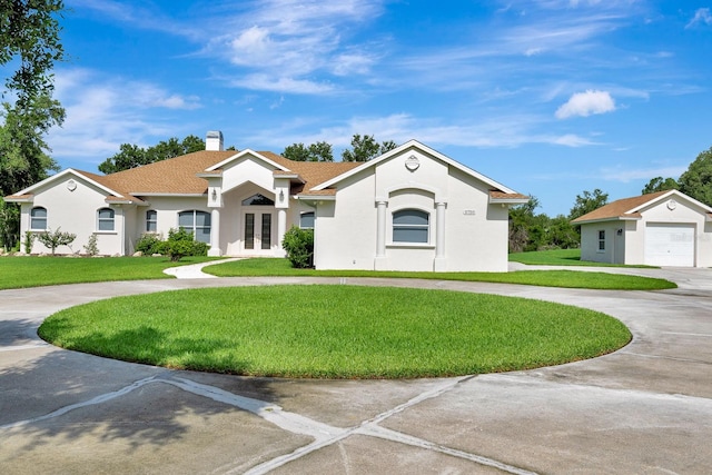 5750 Saddle Oak Trl, Sarasota, FL 34241 - view of front of property with french doors, curved driveway, a front lawn, and a chimney