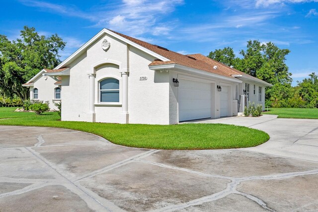 5750 Saddle Oak Trl, Sarasota, FL 34241 - view of front of home featuring an attached garage, a front yard, driveway, and water heater