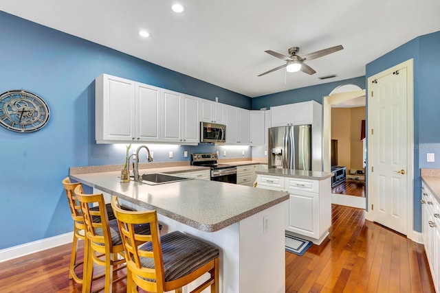 5750 Saddle Oak Trl, Sarasota, FL 34241 - kitchen with appliances with stainless steel finishes, a ceiling fan, hardwood / wood-style floors, a kitchen breakfast bar, and a kitchen island