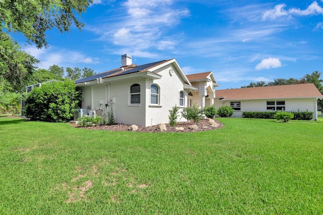 5750 Saddle Oak Trl, Sarasota, FL 34241 - view of side of home featuring stucco siding, a chimney, and a lawn