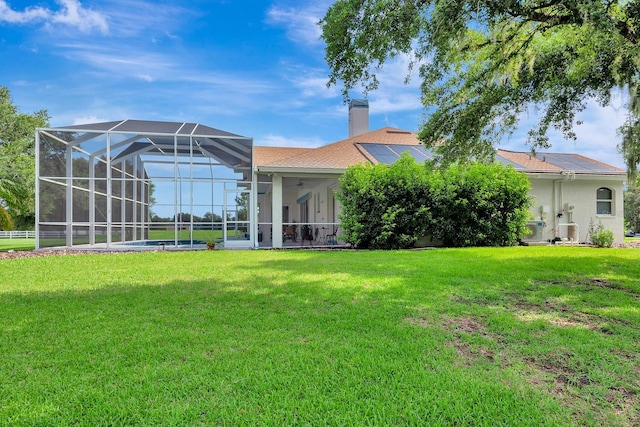 5750 Saddle Oak Trl, Sarasota, FL 34241 - back of property with a lawn, a ceiling fan, a chimney, stucco siding, and glass enclosure