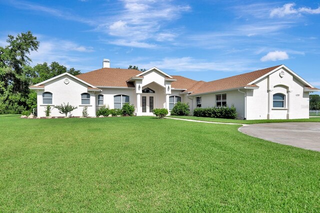 5750 Saddle Oak Trl, Sarasota, FL 34241 - ranch-style house with french doors, a front lawn, stucco siding, and a chimney