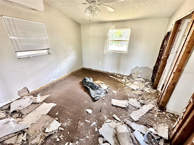 empty room with ceiling fan and a textured ceiling