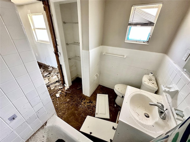 bathroom with tile walls, sink, and toilet