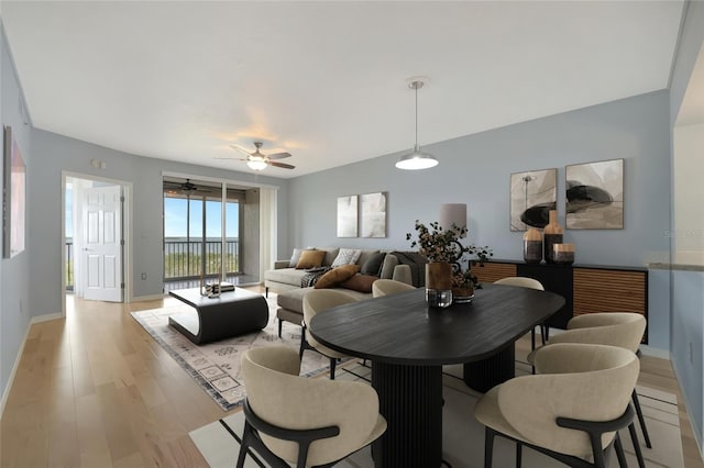 dining room featuring ceiling fan, light wood-style flooring, and baseboards