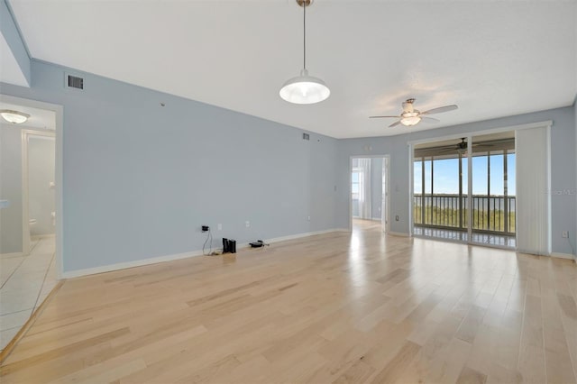 unfurnished living room featuring light wood-type flooring, baseboards, and a ceiling fan