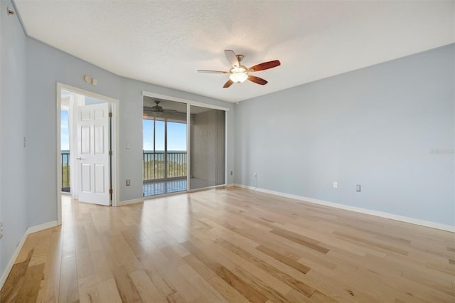 empty room featuring a textured ceiling, baseboards, a ceiling fan, and light wood-style floors