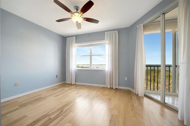 unfurnished room with ceiling fan, light wood finished floors, and baseboards