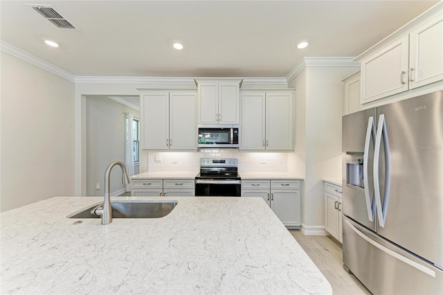 kitchen featuring sink, light stone counters, ornamental molding, stainless steel appliances, and decorative backsplash