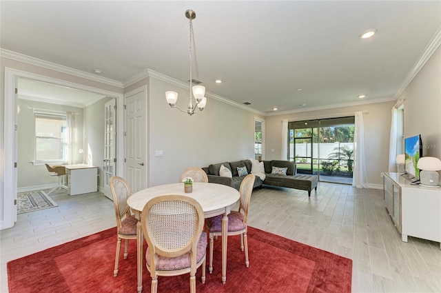 dining space featuring crown molding, a chandelier, and light hardwood / wood-style floors