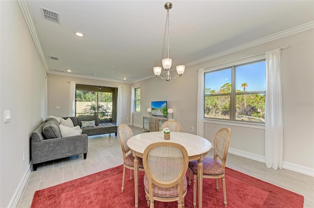 dining space with hardwood / wood-style floors, crown molding, and a chandelier