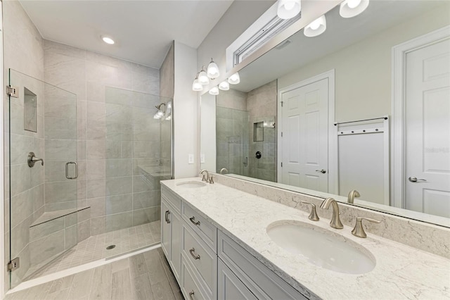 bathroom with vanity and a shower with door