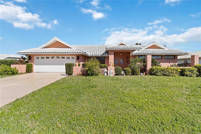 view of front of home with a tile roof, driveway, a front lawn, and stucco siding