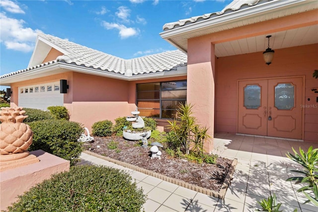 534 Warwick Ln, Venice, FL 34293 - property entrance featuring an attached garage, stucco siding, and a tiled roof