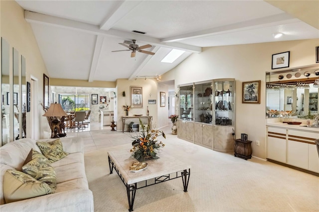 534 Warwick Ln, Venice, FL 34293 - living room featuring lofted ceiling with skylight, visible vents, light carpet, and a ceiling fan