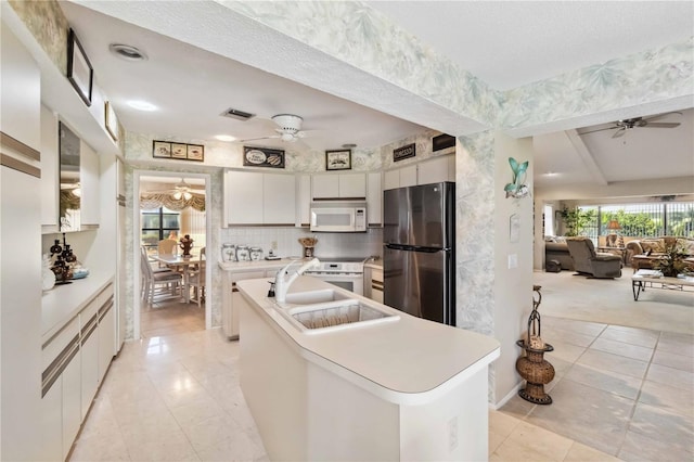 534 Warwick Ln, Venice, FL 34293 - kitchen featuring white appliances, a center island with sink, a ceiling fan, open floor plan, and white cabinetry