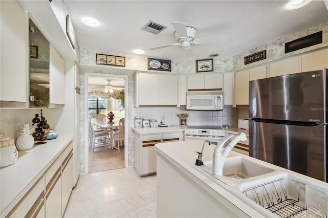 534 Warwick Ln, Venice, FL 34293 - kitchen featuring white appliances, visible vents, light countertops, and backsplash