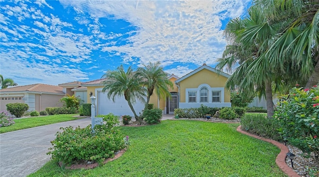 view of front of house with a garage, driveway, a front lawn, and stucco siding