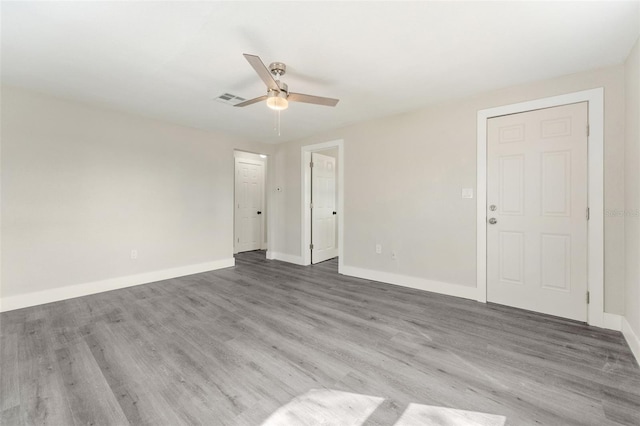 interior space featuring baseboards, ceiling fan, visible vents, and wood finished floors