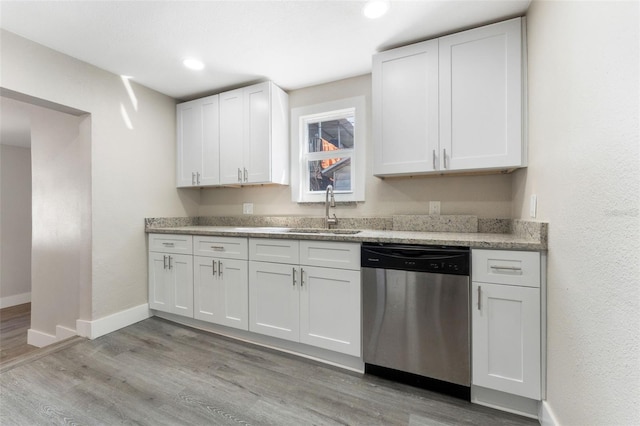 kitchen featuring baseboards, a sink, white cabinetry, light wood finished floors, and dishwasher