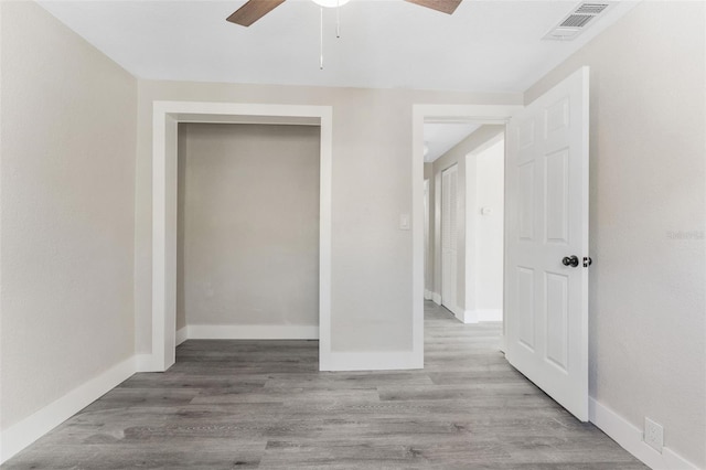 unfurnished bedroom with baseboards, visible vents, a ceiling fan, and light wood-style flooring