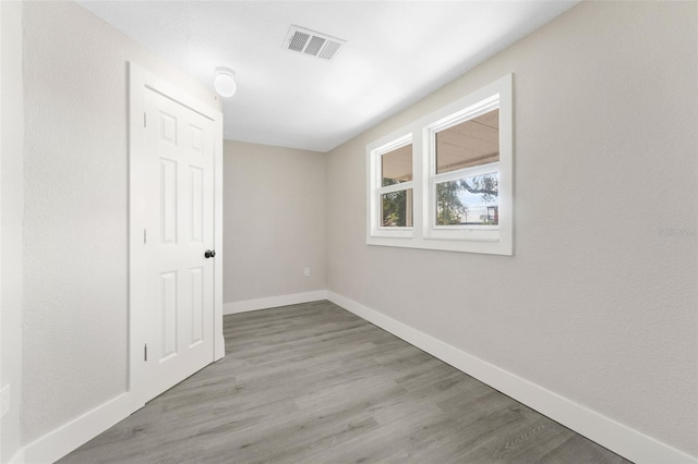 empty room featuring baseboards, visible vents, and light wood-style floors