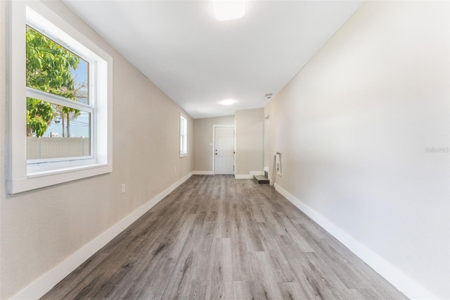 laundry room featuring baseboards, light wood-type flooring, and plenty of natural light