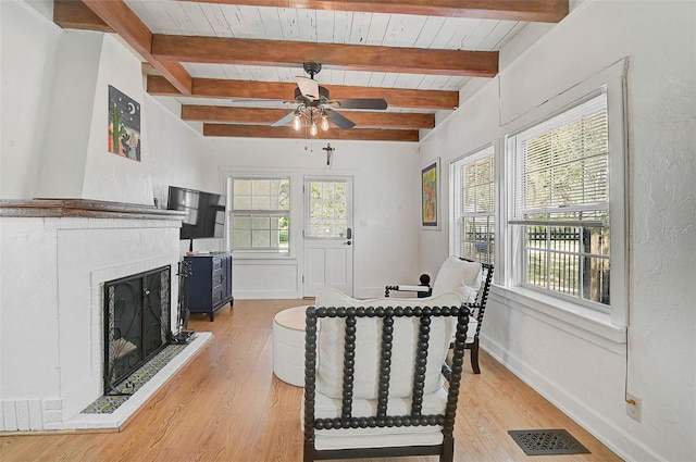 interior space with ceiling fan, wood ceiling, light hardwood / wood-style flooring, and beamed ceiling