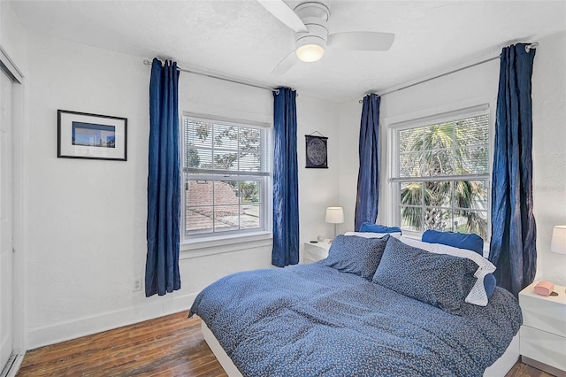 bedroom featuring a textured ceiling, dark wood-type flooring, and ceiling fan