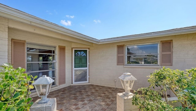 view of exterior entry featuring a patio