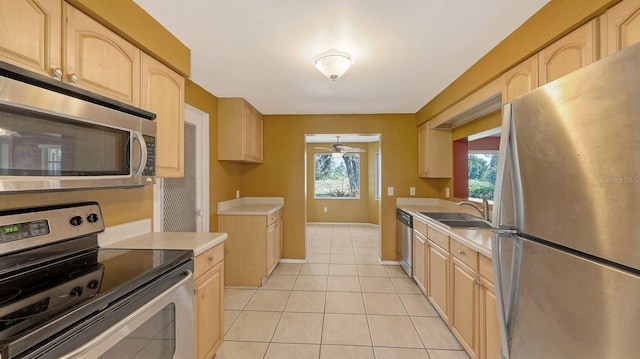 kitchen featuring stainless steel appliances, sink, light tile patterned floors, and light brown cabinetry