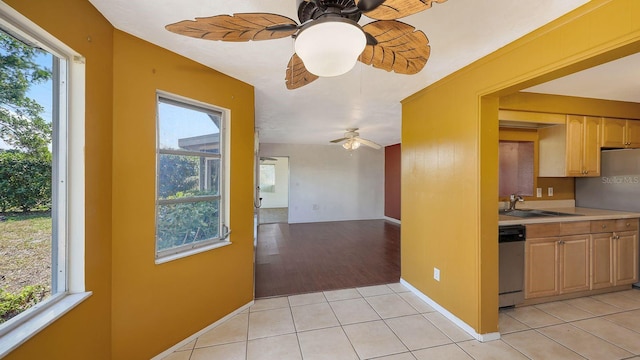 kitchen with sink, light tile patterned floors, light brown cabinets, appliances with stainless steel finishes, and a wealth of natural light