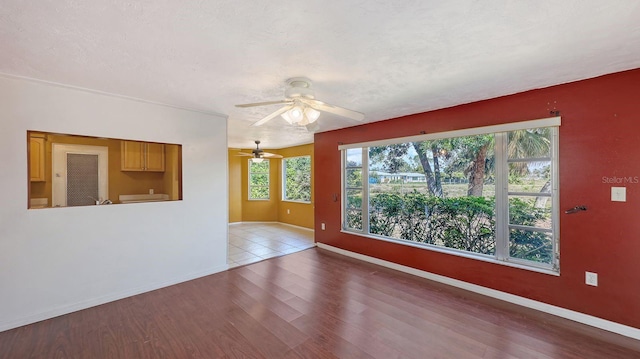 spare room with hardwood / wood-style floors, a textured ceiling, and ceiling fan