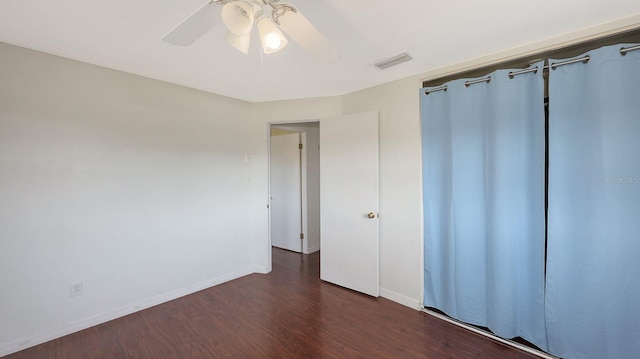 unfurnished bedroom with ceiling fan and dark hardwood / wood-style floors