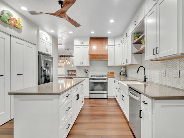 kitchen with stainless steel appliances, white cabinetry, custom exhaust hood, and open shelves