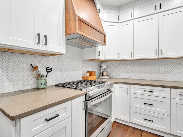 kitchen with white cabinets, custom exhaust hood, and gas range