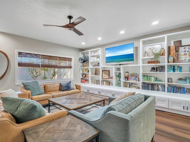 living area with a textured ceiling, ceiling fan, dark wood-style flooring, and recessed lighting