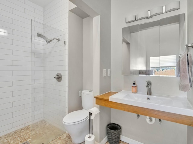 bathroom with a walk in shower, a sink, and toilet