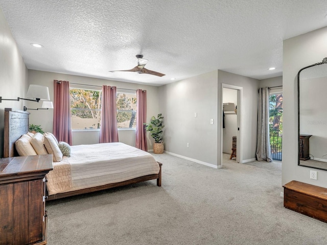 bedroom with baseboards, ceiling fan, multiple windows, and light colored carpet