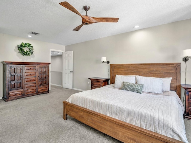 bedroom featuring light carpet, baseboards, visible vents, a ceiling fan, and a textured ceiling