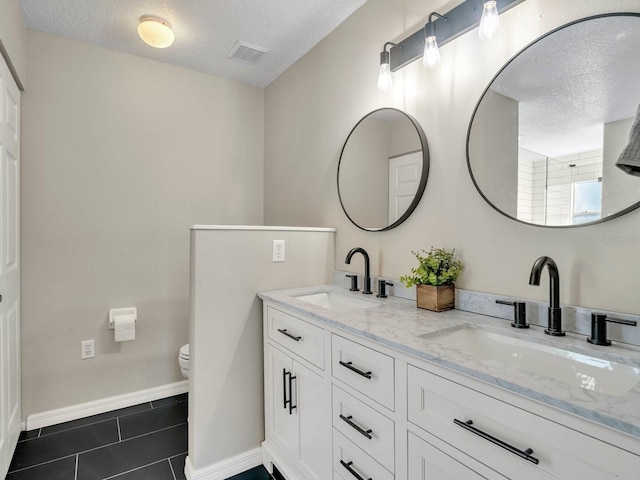 bathroom featuring visible vents, a sink, a textured ceiling, and tile patterned floors