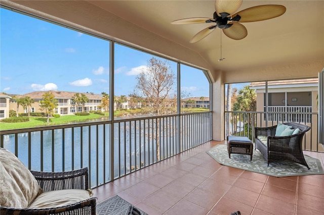 sunroom / solarium with a water view, ceiling fan, and vaulted ceiling