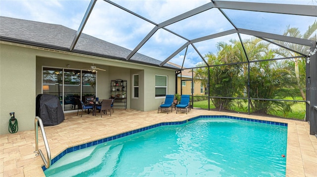 pool with a ceiling fan, glass enclosure, and a patio