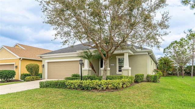 view of front of home featuring a garage, a front yard, driveway, and stucco siding