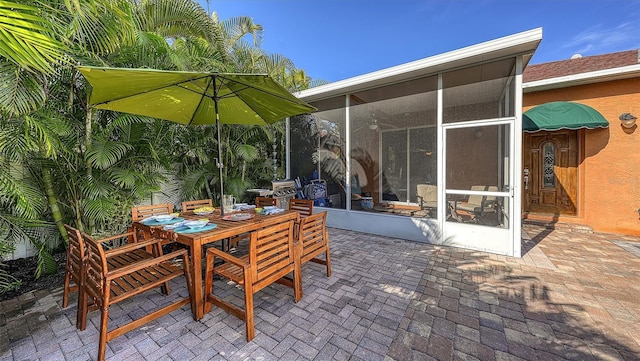 view of patio with outdoor dining area and a sunroom